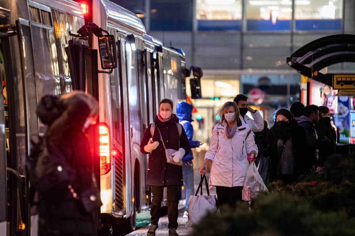 Ihmisiä poistuu ja menee bussiin Espoon Matinkylässä.
