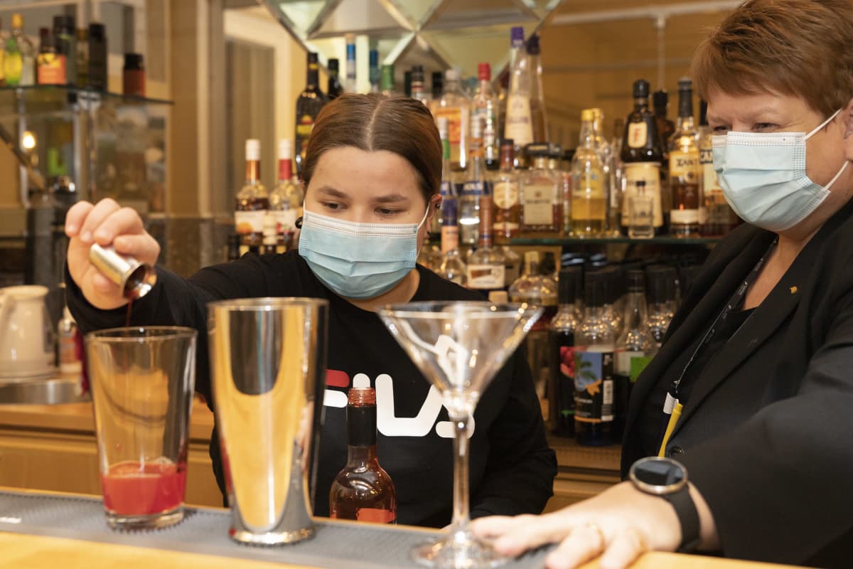 ravintola-alan opiskelija Elisa Ruotsalainen valmistaa drinkkiä lehtori Terhi Saarisen opastuksessa.