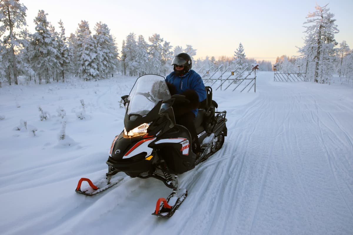 Moottorikelkkailija pysähtyneenä kelkkareitille.