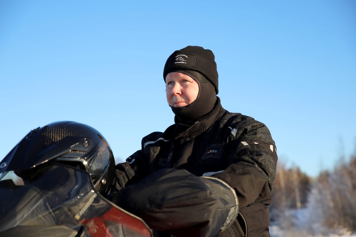 Matti Simola istuu varusteissaan moottorikelkan päällä
