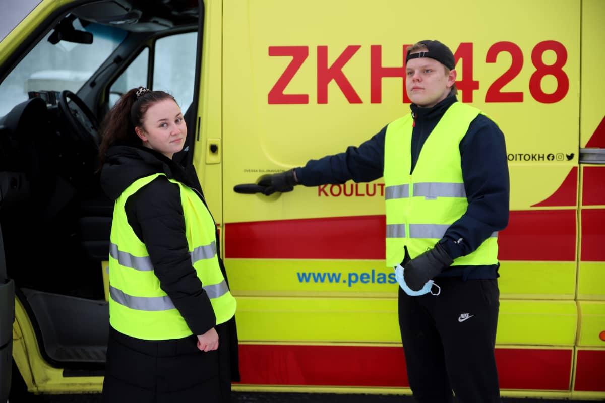 Ensihoidon opiskelijat Mona Ilmanen ja Eetu Hyvärinen ambulanssin edessä.