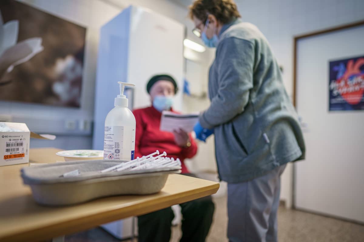 Sairaanhoitaja Seija Ovaskainen kertoo Toimi Heikkilälle koronarkotuksen toisesta vaiheesta.