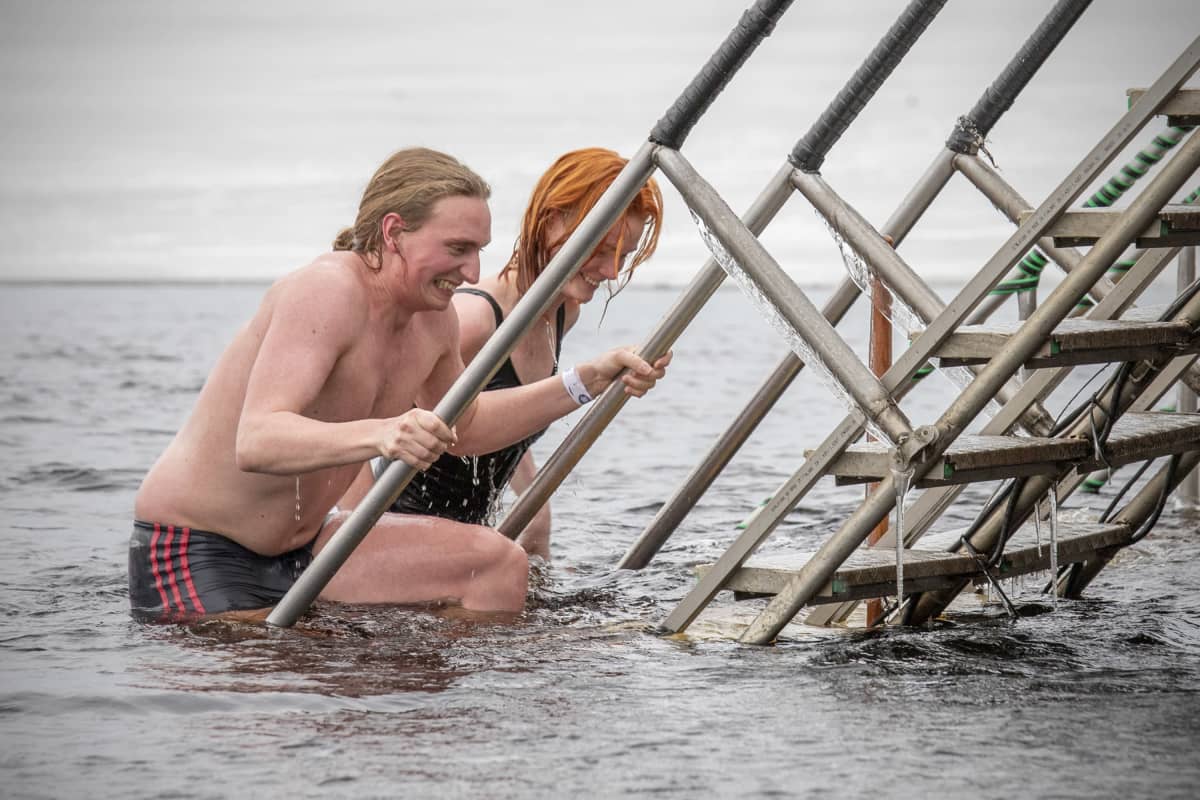 Juhana Jämsen ja Auli Sipola nousevat avannosta portaita pitkin.