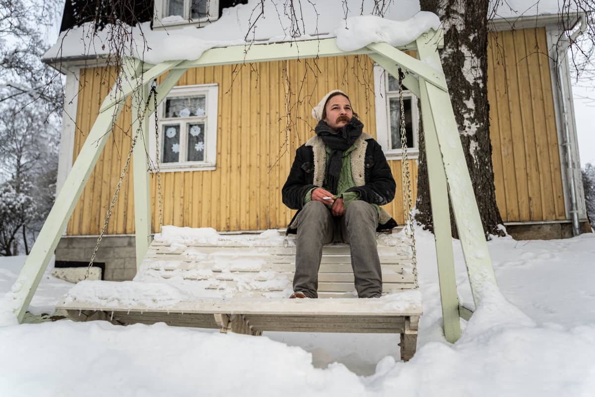 Lassi Valtonen katselee mietteliäänä ja istuu keinussa