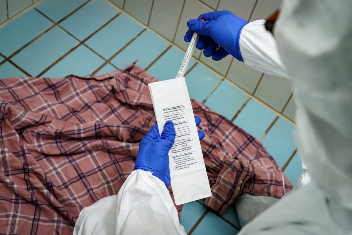 Rikospaikkatutkija laittamassa DNA-näytteen todistenäytepussiin.