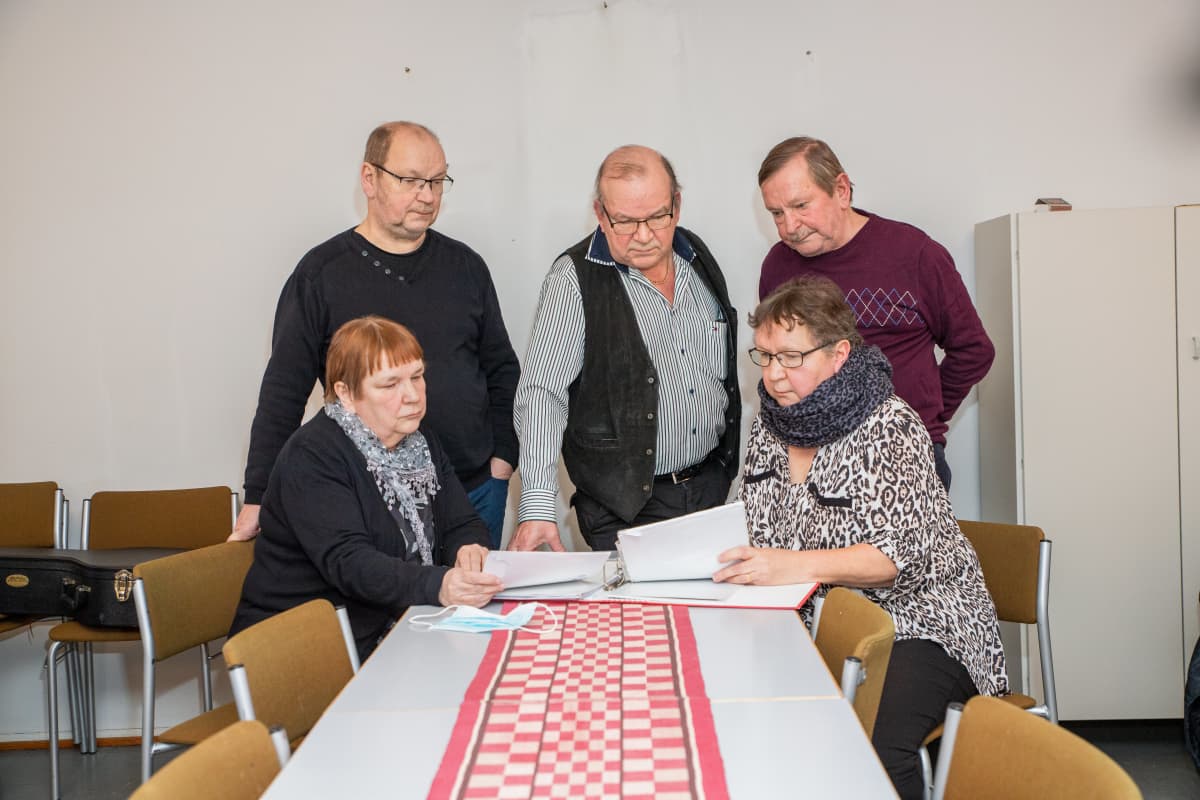 Sisarukset katsovat vanhoja dokumentteja