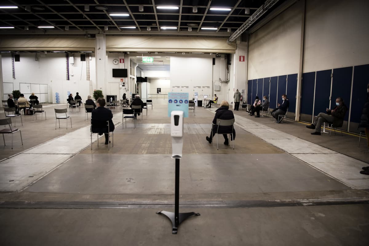 Asiakkaat jonottavat Messukeskuksen rokotuspisteen odotusaulassa.