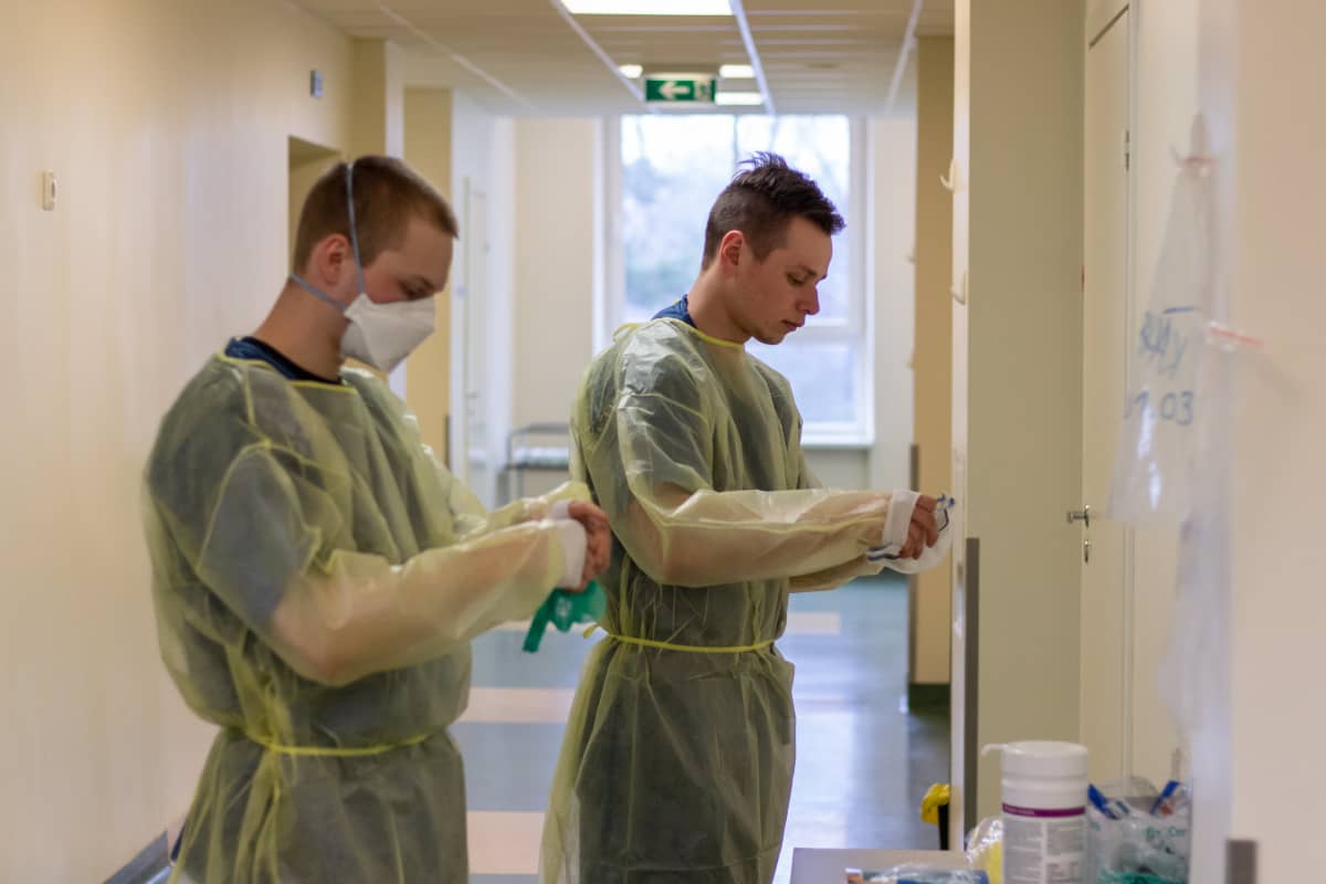 Varusmieslääkintämiehet pukevat suojavarusteitaan Länsi-Tallinnan keskussairaalan koronaosastolla.