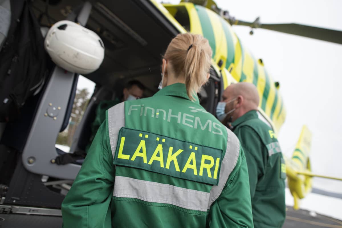 Lääkäri keskustelee helikopterihenkilökunnan kanssa.