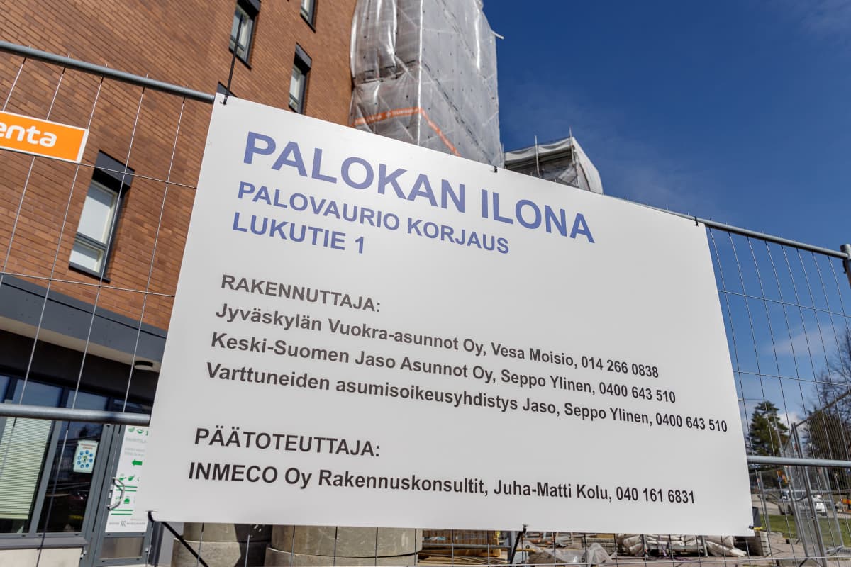 Kyltissä lukee Palokan Ilona, Palovaurion korjaus. Taustalla huputettu kerrostalo.