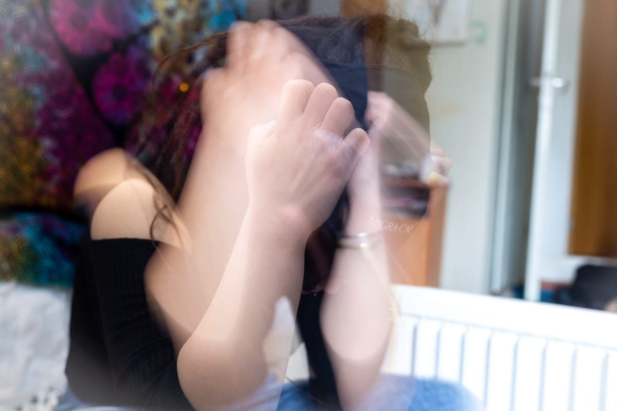 Emma Rask heiluttaa käsiään epätoivoisesti päänsä ympärillä siten, että käsien liike näkyy kuvassa ja peittää kasvot.