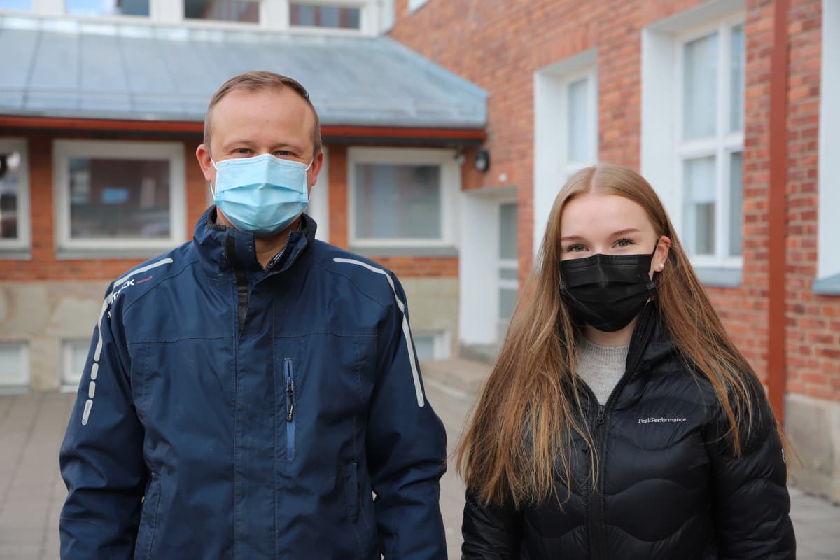 Osmo Rauhala ja Unna Karppinen seisovat Rovaniemen Lyseonpuiston pihalla maskit päässä.
