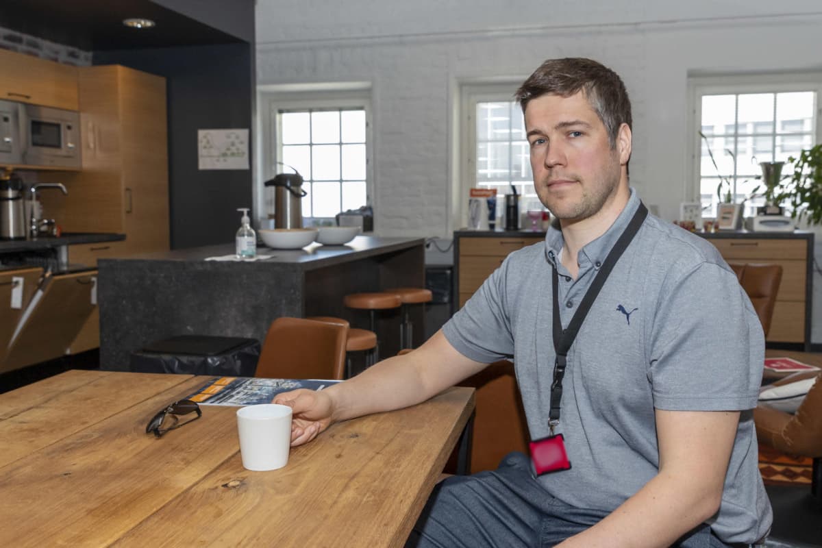 Jaakko Kaski pöydän ääressä kahvikuppi kädessä.