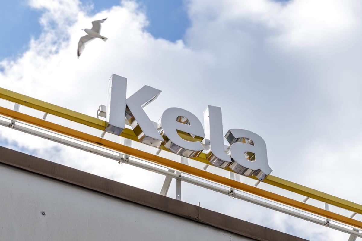 Kelan katolla oleva teksti: Kela. Tekstin vieressä lentää lokki.