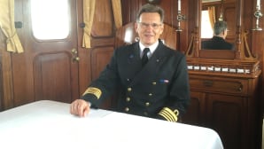 S/S Saimaan päällikkö Jukka Väisänen hymyilee laivan salongissa.