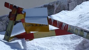 Kuvassa puinen puomi talon kulmalla vaoittamassa katolta putoavista lumista.