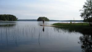 Kalastaja laiturilla järvimaisemassa