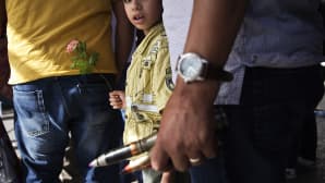 Libyalaispoika pitelee kukkaa ja hänen isänsä isokaliiberisia ammuksia, jotka hän aikoo luovuttaa viranomaisille.