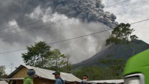 Paikalliset asukkaat pakenevat purkautuvan Sinabung-tulivuoren syöksemien kivenlohkareiden ja tuhkapilven alta.