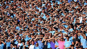 Manchester Cityn kannattajat suojaavat silmiään auringolta paikalliskamppailussa Manchester Unitedia vastaan Etihad-stadionilla.