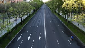 Pyöräilijä autoista tyhjällä kuusikaistaisella tiellä.