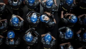 Filippiiniläispoliisi katsoi kameraan poliisien seuratessa mielenosoitusta Manilassa 19. marraskuuta.