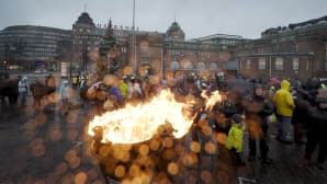 Ihmisiä ja suuressa padassa palava tuli Hakaniemen torilla.