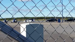 Moottoripyöräpoliisit, poliisit ja kaupungin viranomaiset odottavat ajoneuvoissaan Norjan kuningasparin saapumista Oulun lentokentälle.