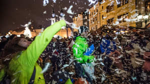 Ihmisiä leikkimässä tyynysotaan Prahan jouluisessa vanhassa kaupungissa.