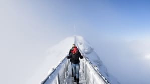 Kaksi turistia ylittävät riippusiltaa Col du Pillonissa Sveitsissä 20. joulukuuta.