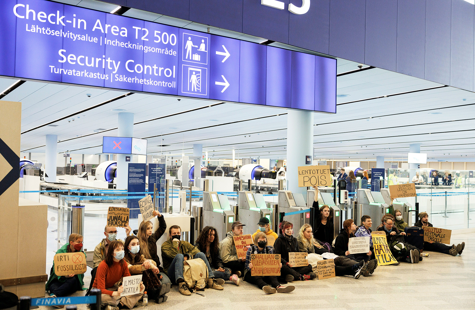 Passagiere steigen trotz einer Demonstration am Extinction Rebellion Airport in das Flugzeug ein