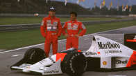 Ayrton Senna ja Alain Prost poseeraavat F1-auton vieressä.