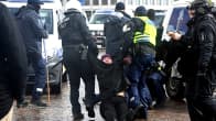 Poliisit raahaavat mielenosoittajaa Kauppatorilla.
