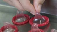 Laborantti tutkii kondomeja thaimaalaisella tehtaalla.
