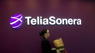 Nainen kävelee seinässä olevan TeliaSoneran logon ohitse.