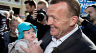 Venstre-puolueen johtaja Lars Loekke Rasmussen poseeraa kuvaajille vauva sylissään.