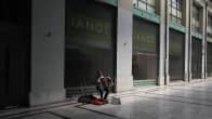 Yksinäinen katumuusikko autiolla ateenalaisella kadulla.