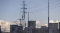 High-tension wires with blocks of flats in the background on a winter day.