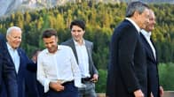 Viisi maailman johtajamiestä naureskelee ruskaisessa, aurinkoisissa alppimaisemassa. Yhdysvaltojen presidentti Joe Biden pitää kättä Ranskan-kollegansa Emmanuel Macronin olkapäällä.