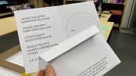 Saamelaiskäräjävaalien äänestyslippu kädessä.