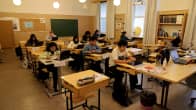 Ett klassrum med elever sittande vid sina pulpeter.