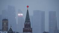 A red star on top of the Moscow Kremlin tower, with the city skyline in the background.