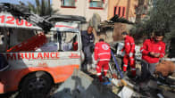 Pelastustyöntekijät tutkivat tuhoutunutta ambulanssia raunioissa.