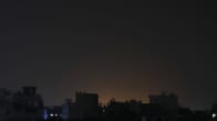 Öisessä Jemenin pääkaupunki Sanaassa rakennusten takaa kajastaa valo kaupunkiin kohdistuneiden iskujen jälkeen.