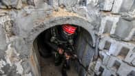 Palestiinalaistaistelija konepistooli kädessään tunnelin suulla.