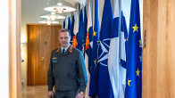 General Janne Jaakkola, Commander of the Finnish Defence Forces, with the Finnish, NATO and EU flags in the background.