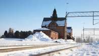 Haaparannan rautatieasema talvella, edustalla raiteet. Lunta on maassa ja rakennuksen katolla.