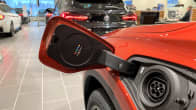 Punaisen sähköauton latauspistoke. Kuva autosta otettu Lahden Laakkosen autoliikkeessä. 