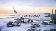 Ett Finnairflyg på marken vid Helsingfors-Vanda flygplats. På marken finns snö. I bakgrunden syns rodnad himmel.