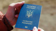 Lähikuva Ukrainan passista naisen käsissä.